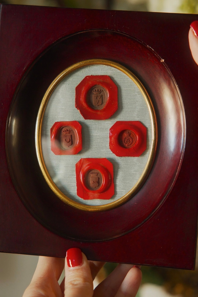 Framed Collection of Four Heraldic Wax Seal Impressions in a Burgundy-Toned Frame